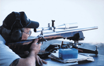 A man shooting a rifle in a gun range