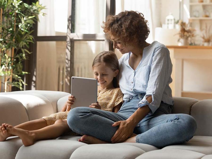 A mother and daughter looking at a tablet together
