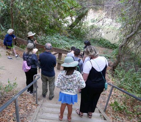 People standing on stairs leading down to view of Uvas Creek