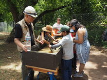 Volunteers helps event participants pan for gold in a trough during a previous Play Like a Miner Event