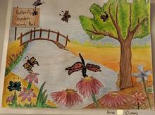 aaron's colorful drawing of a park, with a sign saying butterfly garden county park, butterflies surrounding the sign and near flowers, trees, flowers, a pond with a bridge over it