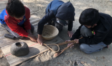 Three children working in a group to process acorns using traditional Amah Mutsun tools and methods.