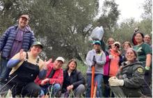 Santa Clara County Parks staff and volunteers posing together holding weeding tools