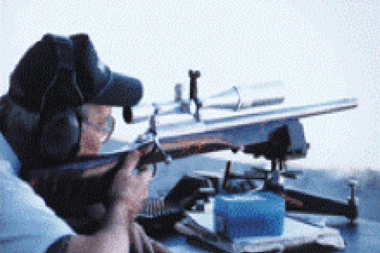 A man aiming a rifle at a gun range
